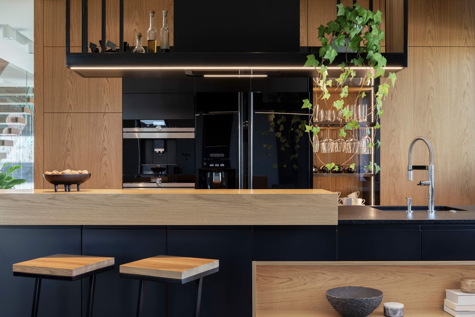 Moderne Küche mit Holzvertäfelung und schwarzen Akzenten